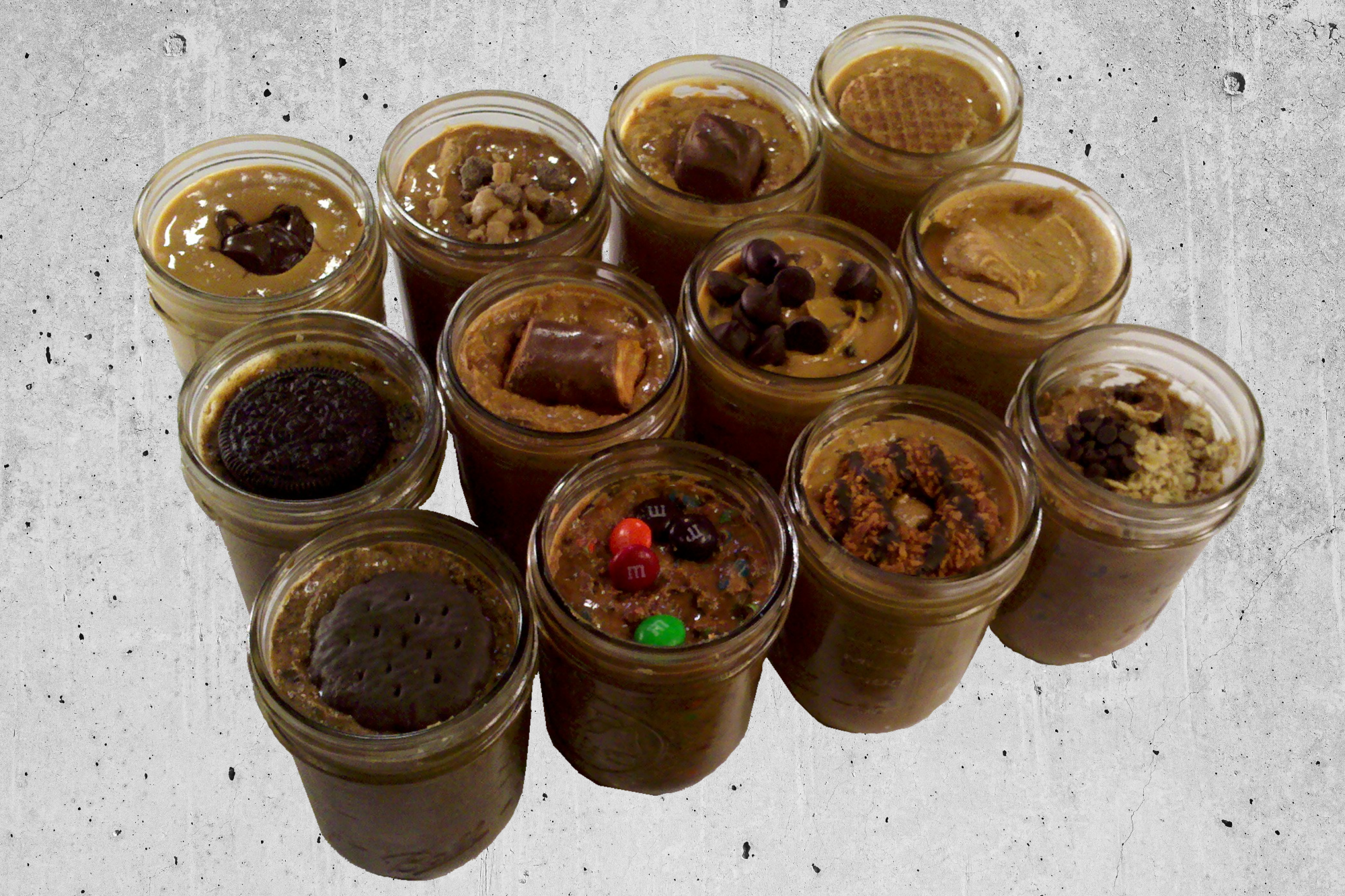 A dozen RunnerButter jars of various flavors.