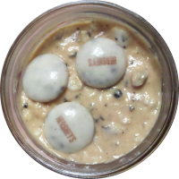 An image of homemade peanut butter with cookies and cream pieces mixed in.