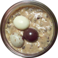 An image of homemade peanut butter with chocolate covered espresso bean chunks mixed in.